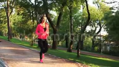 年轻女子在阳光明媚的城市公园<strong>跑步户外运动</strong>。 稳定射击，慢动作。 上午